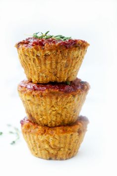 three muffins stacked on top of each other with sauce and herbs in the middle