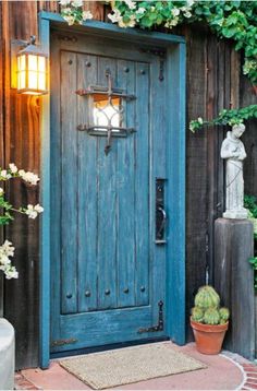 a blue wooden door surrounded by greenery and potted plants