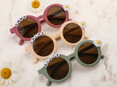 three pairs of sunglasses with the word choice written on them and daisies in front of them