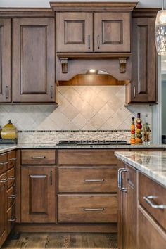 a kitchen with wooden cabinets and marble counter tops