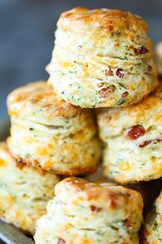 several biscuits stacked on top of each other in a metal pan with cheese and bacon toppings