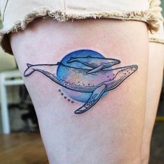 a woman's thigh with a whale tattoo on it