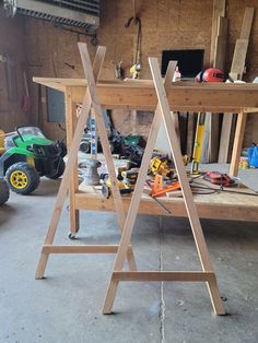 two wooden workbenches in a garage with tools on the table next to them