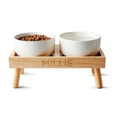 two white bowls on wooden trays with the word'mile'written across them