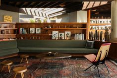 a living room filled with furniture and bookshelves on the wall next to each other