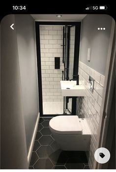 a white toilet sitting next to a sink in a bathroom