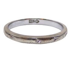 a white gold wedding ring with an inscription on it