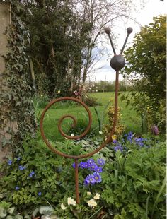 a metal sculpture in the middle of a garden