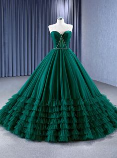 Quintessentially captivating, this prom dress features a sculpted bodice that artfully frames the decolletage, drawing attention to the delicate yet determined lines of the heart-shaped neckline. The rich emerald green velvet hugs the figure before exploding into a sea of structured tulle ruffles, creating a breathtaking ballgown silhouette that promises to leave a lasting impression. As regal as it is refreshing, this gown is a celebration of classical beauty with a modern twist. Each ruffled layer adds a touch of whimsy to the grandeur, inviting a sense of playful sophistication to an evening of elegance. Perfect for a night where every detail counts, this dress is an unforgettable emblem of style. Emerald Green Lace Dress, Green Ball Gown, Classical Beauty, Tulle Ruffles, Emerald Green Velvet, Red Quinceanera Dresses, Green Tulle, Green Lace Dresses, Spaghetti Strap Prom Dress