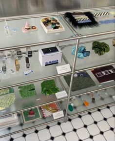 a display case filled with lots of different types of items on glass shelves next to tiled flooring