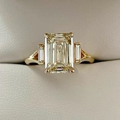 an emerald cut diamond ring with three baguets