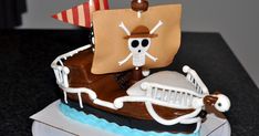 a cake decorated to look like a pirate ship with a skeleton on it's side