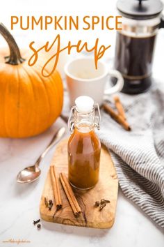 pumpkin spice syrup in a glass jar on a cutting board with cinnamon sticks and coffee