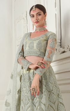 COLOR : Dusty Mint Green FABRIC : Top (Blouse) - Net, Bottom (Lehenga) - Net, Inner - Silk Satin & Premium Can-Can, Dupatta - Net WORK : Heavy Silk Thread Embroidery, Heavy Stone Work, Cutwork, Cording Embroidery OCCASION : Wedding, Reception, Sangeet, Engagement READY-TO-WEAR : NoSTITCHING : Available as semi-stitched fabric, can be stitched using standard size option (+$30). Note: There might be a slight color variation due to lighting and flash used during photoshoot. The bright shade seen is Cording Embroidery, Lehenga Green, Mint Green Fabric, Embroidered Bridal Lehenga, Net Lehenga, Embroidered Lehenga, Can Can, Stone Work, Green Tops