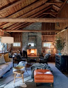 a living room filled with furniture and a fire place in the middle of it's walls