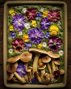 mushrooms and pansies in a tray on a table