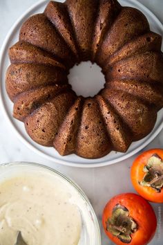 a bundt cake sitting on top of a white plate next to tomatoes and dip