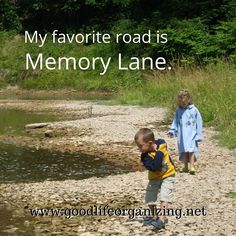 two young boys are walking along the river bank with their hands in each others pockets