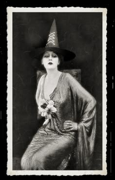 a woman wearing a witches hat and sitting in a chair