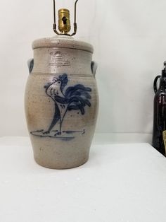 a vase with a bird painted on it next to two other vases and a lamp