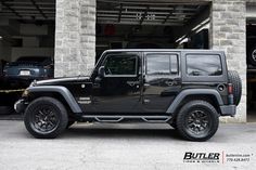 a black jeep parked in front of a building