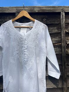 ☀️A personal favourite, get this classic piece for a timeless elegant yet casual look - hand embroidered white chikankari kurta in a pure soft cotton fabric. Light and airy, the most comfortable kurta you will ever own!    Hand made with a lot of love and attention to detail in the heart of India.    Pair it with linen pants for day out in the sun or white pyjamas for a perfect relaxed day at home.    Features embroidery on yoke, hem, back, and sleeves.    Delicate hand wash only.    NO RETURNS Bohemian White Kurta With Chikankari Embroidery, White Bohemian Kurta With Chikankari Embroidery, Traditional White Summer Kurta, Traditional White Kurta For Summer, Bohemian Cotton Kurta With Cutwork, White Cotton Kurta With Floral Embroidery, Summer Wedding Cotton Kurta, White Pajamas, Relaxing Day