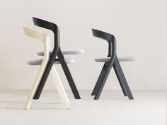 two chairs sitting side by side in front of a white wall