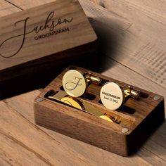 two personalized cufflinks in a wooden box on a wood table with the name groomsman written on them