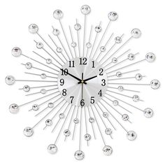 a white clock with lots of silver balls on it's face and numbers in the middle