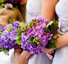 the bridesmaids are holding their bouquets with purple flowers