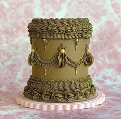 a three tiered cake decorated with green icing and beaded trimmings