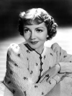 an old black and white photo of a woman wearing a sweater with stars on it