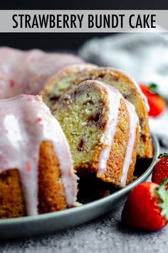 strawberry bundt cake with icing and strawberries in the background on a plate