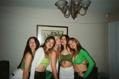 four girls in green and white outfits posing for the camera with their arms around each other