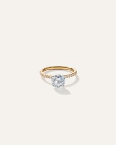 a yellow gold ring with a white diamond