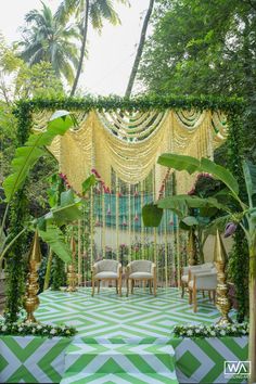 an outdoor wedding setup with chairs and greenery