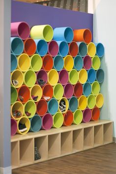 the shelves are filled with different colored plastic cups on them, and there is also a shelf that holds several pairs of shoes