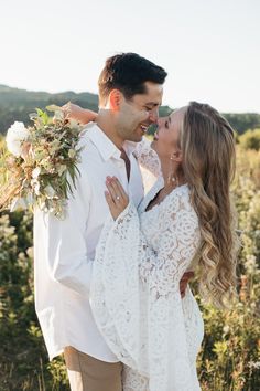 a man and woman are kissing in the field