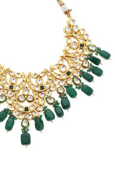 22k gold plated half crescent shaped pendant necklace with green kundan, stone embellishment and bead drops. Comes with earrings.
Components: 1 Necklace, Pair of earrings
Type: Kundan, Stone, Bead
Composition: Mixed Metal Alloy
Color: Green
Other Details: 
Dimensions L x B x H (in cm):
Necklace: 46 x 9.4 x 1
Earrings: 10 x 4.5 x 1
Weight (in gms): 300
Closure:
Necklace: Pull out drawcord
Earrings: Push back clasp - Aza Fashions Crescent Shape, Jewellery Sets, Green Jewelry, Mixed Metals, 22k Gold, Aza Fashion, Online Jewelry, Crescent, Necklace Set