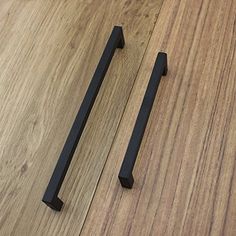 two black handles on a wooden floor