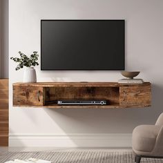 a flat screen tv mounted to the side of a wooden entertainment center in a living room