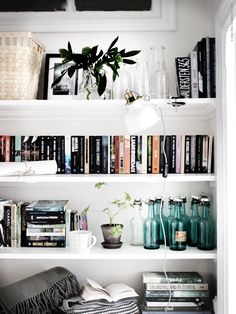 a book shelf filled with lots of books and vases on top of it's shelves