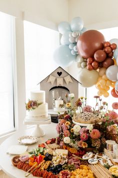 a table topped with lots of food and balloons