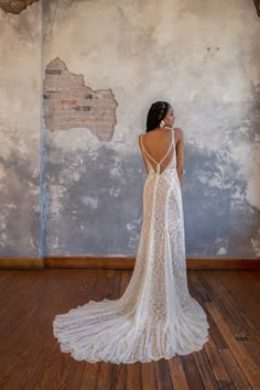 the back of a woman's dress is shown in front of an old wall