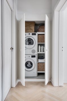 a washer and dryer sitting in a closet next to each other on top of a hard wood floor