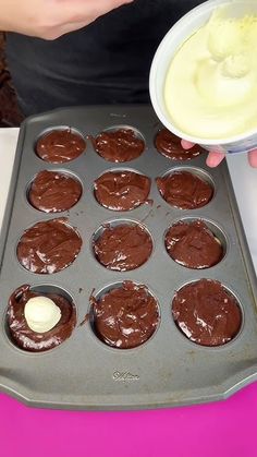 a person holding a plate with cupcakes in it and dipping sauce on top