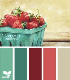 there is a basket full of strawberries on the table with color swatches below it