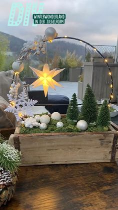 a wooden box filled with fake trees and white balls sitting on top of a table