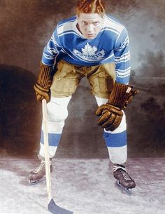 an autographed photograph of a hockey player in uniform, holding a stick and looking at the camera