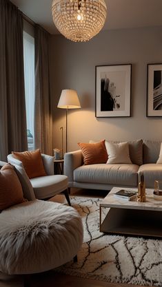 a living room filled with furniture and a chandelier hanging over the top of it